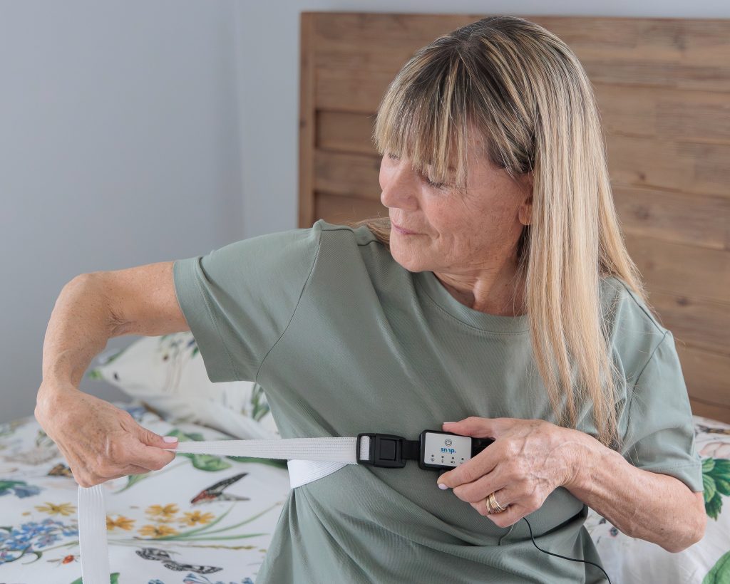 A patient fastening the Snap SAM and chest belt over clothing